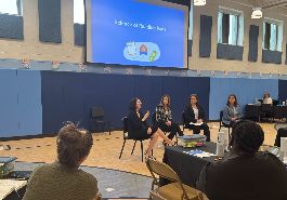  four UCS employees sit on panel with audience listening. project screen behind: science of reading